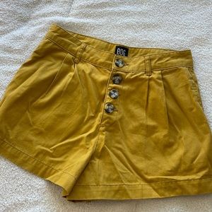 High-waisted button up, mustard yellow BDG shorts.